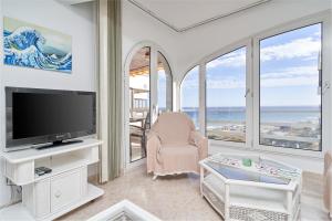 a living room with a tv and views of the ocean at Apartamento Laolita in Torrox