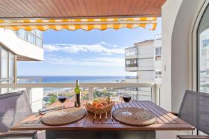 a table with a basket of fruit and wine on a balcony at Apartamento Laolita in Torrox