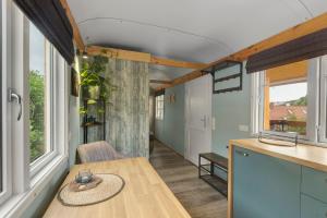 a kitchen and dining room with a table and windows at Tiny House in Lohfelden