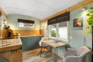 a kitchen with blue cabinets and a table and chairs at Tiny House in Lohfelden +12 photos