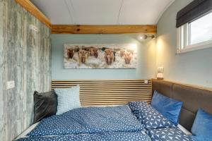 a bedroom with a bed and a painting on the wall at Tiny House in Lohfelden