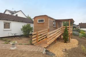 a cabin with a wooden fence in front of a house at Tiny House in Lohfelden
