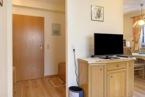 a living room with a television on a cabinet with a door at Ferienwohnung Wagner mit 35 qm Fr in Bad Bellingen