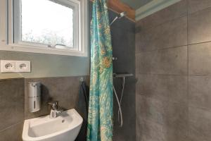 a bathroom with a sink and a toilet and a window at Tiny House in Lohfelden