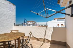 a patio with a wooden table and chairs on a balcony at Villa Isla del Moral in Isla del Moral
