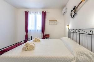 a bedroom with a bed with towels on it at New and Vintage Villa - Anni 50' in Alghero