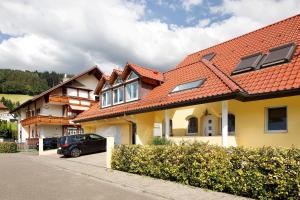a yellow house with a red roof at Ferienwohnung Hörnleberg in Gutach im Breisgau