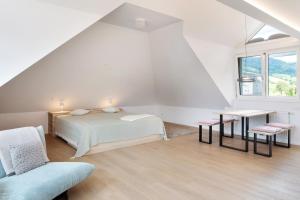 a white bedroom with a bed and a window at Ferienwohnung Hörnleberg in Gutach im Breisgau