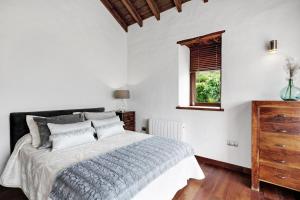 a white bedroom with a large bed and a window at El Portillo 1 in Buenavista del Norte