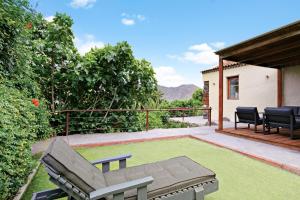 a patio with a bench on a lawn at El Portillo 1 in Buenavista del Norte