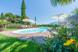a swimming pool in a yard with umbrellas at Weinangerhof St Pauls in Missiano