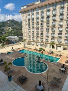 a hotel with a swimming pool in front of a building at Granja Brasil , Studio Itaipava in Araras Petropolis