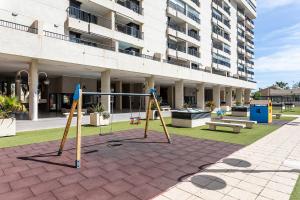 a playground in front of a large building at Valencia Playa in Valencia