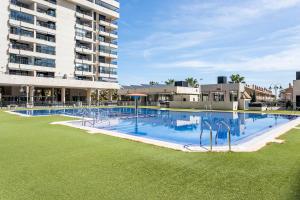 a large swimming pool in front of a building at Valencia Playa in Valencia