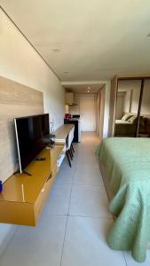 a bedroom with a bed and a desk with a television at Granja Brasil , Studio Itaipava in Araras Petropolis