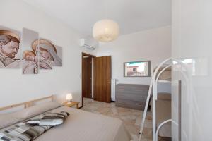 a white bedroom with a bed and a staircase at Bilocale Corosu con 2 balconi in Varazze