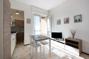 a small kitchen with a table and a television at Bilocale Corosu con 2 balconi in Varazze