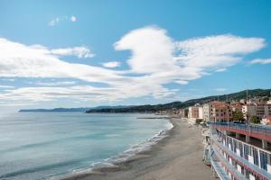 a view of a beach with buildings and the ocean at Bilocale Corosu con 2 balconi in Varazze +14 photos