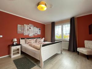 a bedroom with a bed with orange walls and a window at Ferienhaus Sweethome - mit Garten in Bad Sachsa