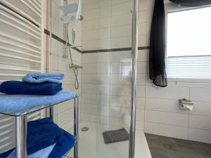 a bathroom with a shower with blue towels at Ferienhaus Sweethome - mit Garten in Bad Sachsa +34 photos