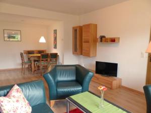 a living room with a couch and chairs and a television at Ferienwohnung am Lerchenweg in Möhnesee