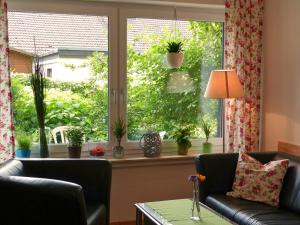 a living room with a window with potted plants at Ferienwohnung am Lerchenweg in Möhnesee +3 photos