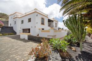 a white house with a palm tree in front of it at Finca Bellavista in Teguise