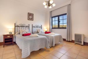 a bedroom with two beds and a window at Finca Bellavista in Teguise +35 photos
