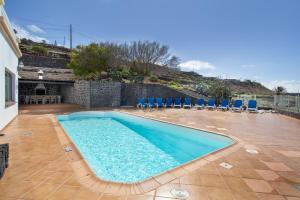 a swimming pool in a yard with chairs and a table at Finca Bellavista in Teguise