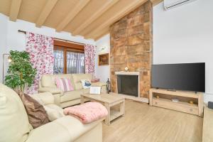 a living room with a couch and a flat screen tv at Villa Dopimar in Rincón de la Victoria