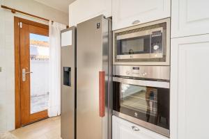 a kitchen with a stainless steel refrigerator and a microwave at Villa Dopimar in Rincón de la Victoria