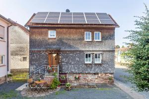 a brick house with solar panels on the roof at Ferienhaus Mittendrin in Jesberg