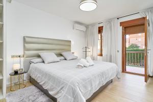 a white bedroom with a large bed and a window at Villa Dopimar in Rincón de la Victoria +30 photos