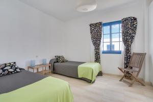 a bedroom with two beds and a window at Casa Rosa in Yaiza