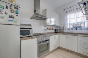 a kitchen with white cabinets and a stainless steel refrigerator at Casa Rosa in Yaiza