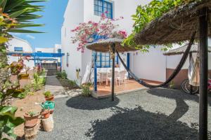 a patio with a hammock and a table and a building at Casa Rosa in Yaiza