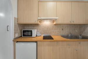 a kitchen with a counter with a microwave and a sink at Parque Carolina 208 in Costa Del Silencio +12 photos