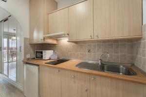 a kitchen with wooden cabinets and a sink at Parque Carolina 208 in Costa Del Silencio