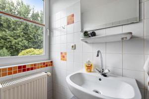 a bathroom with a sink and a window at Ferienhaus Dohle in Vollerwiek +33 photos