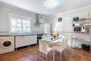 a kitchen with a table and chairs in a room at Villa Cañete in Benamocarra
