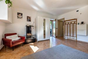 a living room with a red chair and a fireplace at Panoramic Green Studio in Malcesine