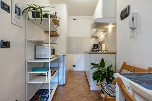 a small kitchen with a white shelving unit at Panoramic Green Studio in Malcesine