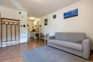 a living room with a couch and a kitchen at Panoramic Green Studio in Malcesine +13 photos