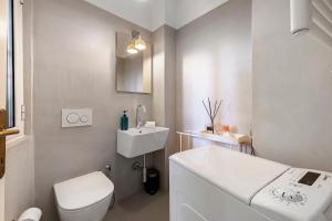 a white bathroom with a toilet and a sink at La Gabbianella - Lake Como in Argegno +33 photos