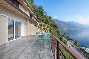 a balcony with a table and chairs and a view of the water at La Gabbianella - Lake Como in Argegno