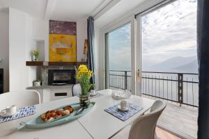 a dining room with a table and a view of the ocean at La Gabbianella - Lake Como in Argegno