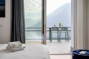 a bedroom with a bed and a view of a balcony at La Gabbianella - Lake Como in Argegno