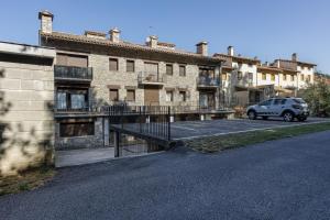 a car parked in a parking lot next to a building at Cal Tatanet in Sant Pau de Segúries