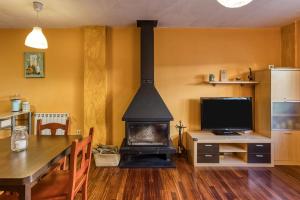 a living room with a fireplace and a table and a television at Cal Tatanet in Sant Pau de Segúries