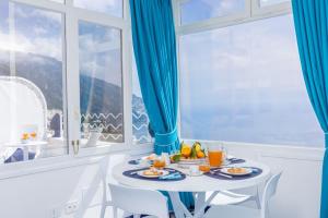 a table with plates of food in a room with a window at Aurora Luxury Suites Seaview in Positano